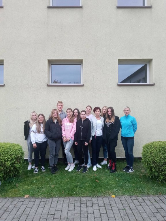 Wolontariusze ze szkolnego klubu wolontariatu podczas sadzenia żonkili przed szkołą.