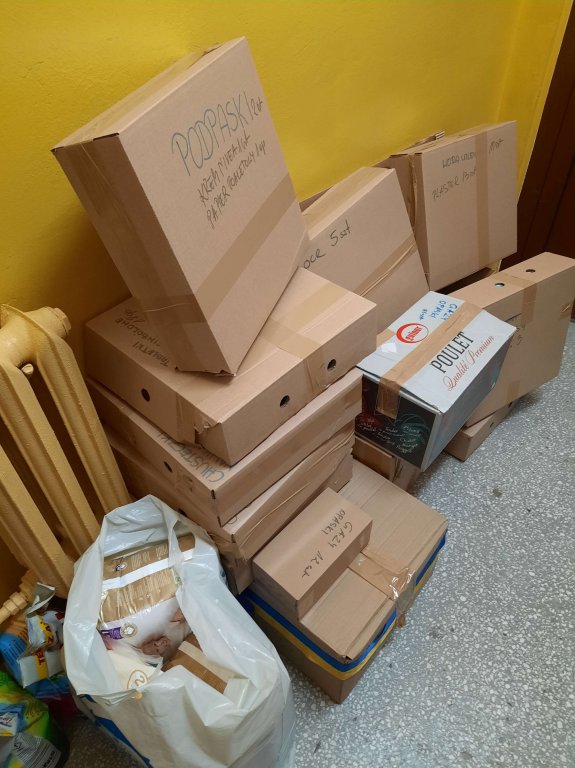 Uczniowie pakują paczki do samochodu