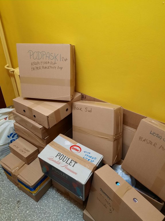 Uczniowie pakują paczki do samochodu