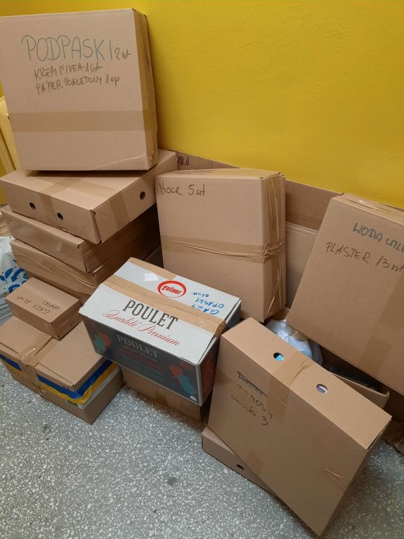 Uczniowie pakują paczki do samochodu