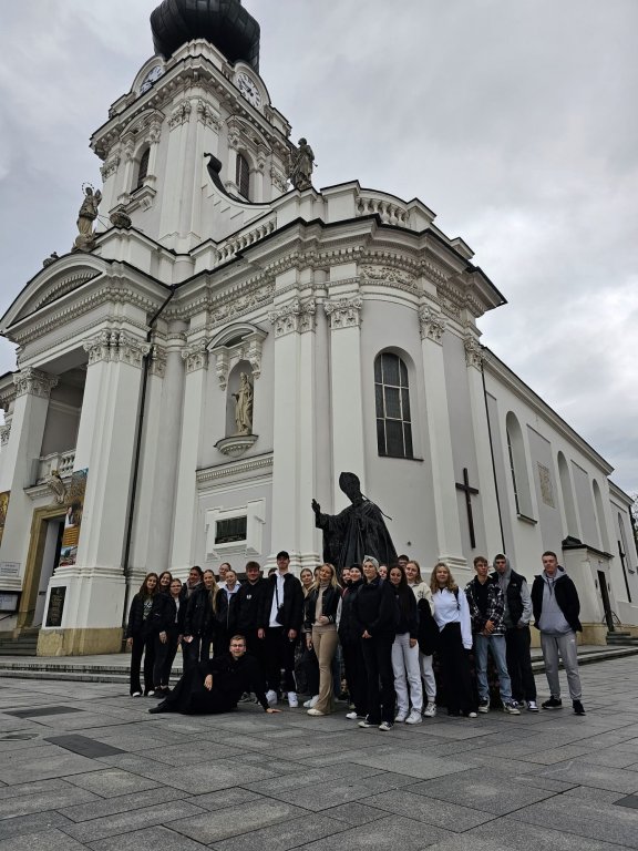 Na zdjęciu grupa młodzieży z księdzem Karolem Sosnowskiem, w tle Bazylika w Wadowicach